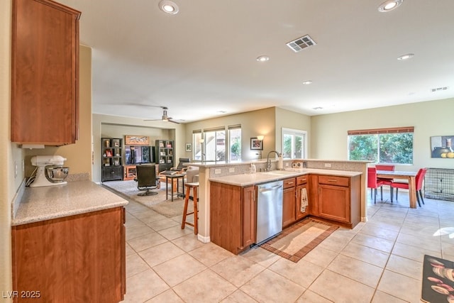 kitchen featuring stainless steel dishwasher, kitchen peninsula, sink, and a wealth of natural light