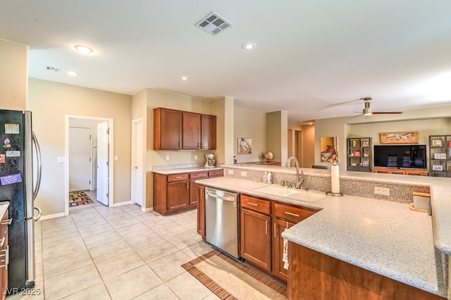kitchen with sink, ceiling fan, stainless steel appliances, light stone countertops, and kitchen peninsula