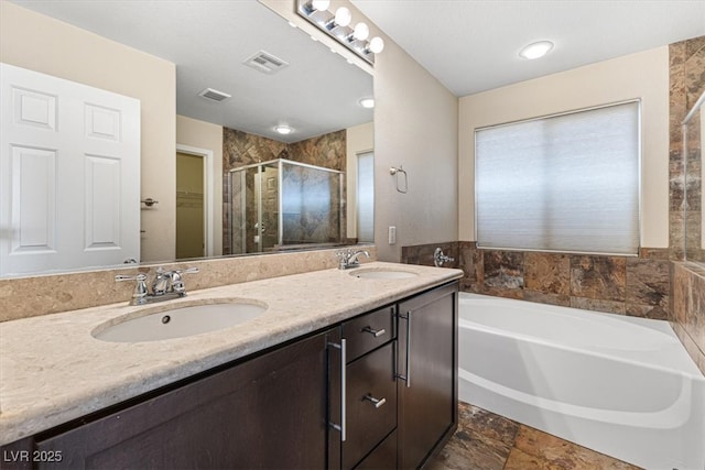 bathroom with a bath, a sink, visible vents, and a shower stall