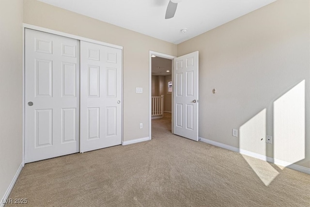 unfurnished bedroom with carpet floors, a closet, ceiling fan, and baseboards