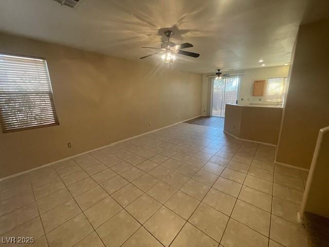 tiled spare room featuring ceiling fan