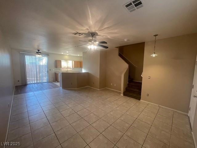 unfurnished living room featuring light tile patterned flooring and ceiling fan