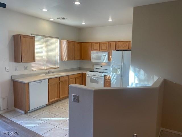 kitchen with sink, light tile patterned floors, and white appliances