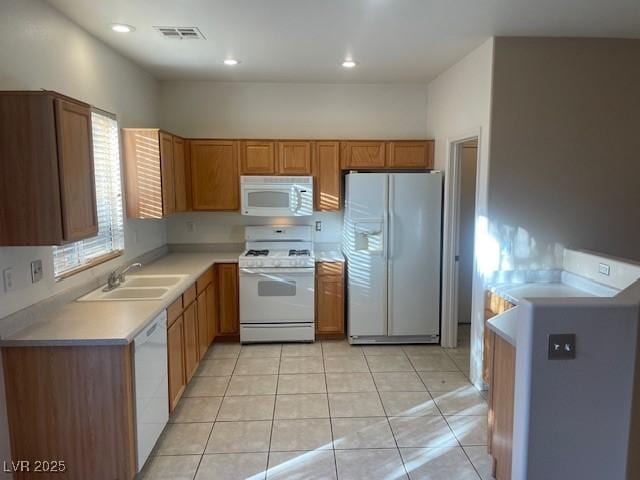 kitchen with sink, light tile patterned floors, and white appliances