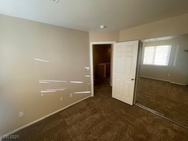 unfurnished bedroom featuring dark colored carpet