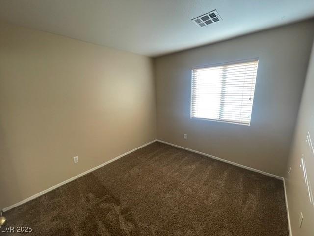 unfurnished room featuring dark colored carpet