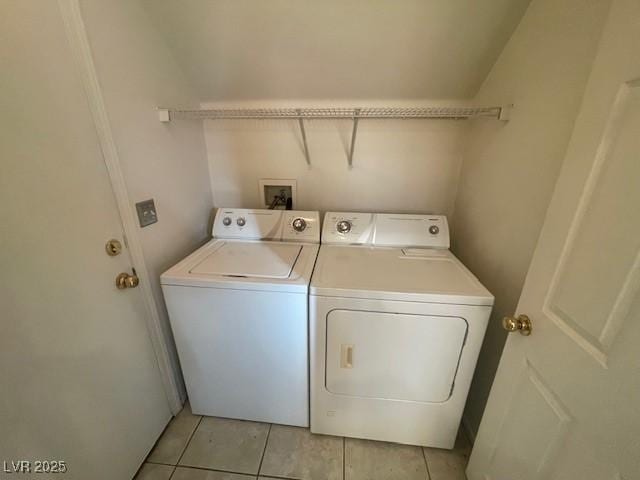 clothes washing area with washing machine and dryer and light tile patterned floors