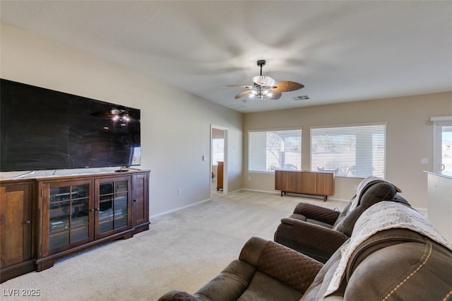 carpeted living room with a wealth of natural light and ceiling fan