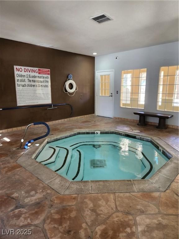 view of swimming pool with an indoor hot tub