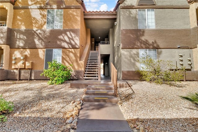 entrance to property with a tiled roof and stucco siding