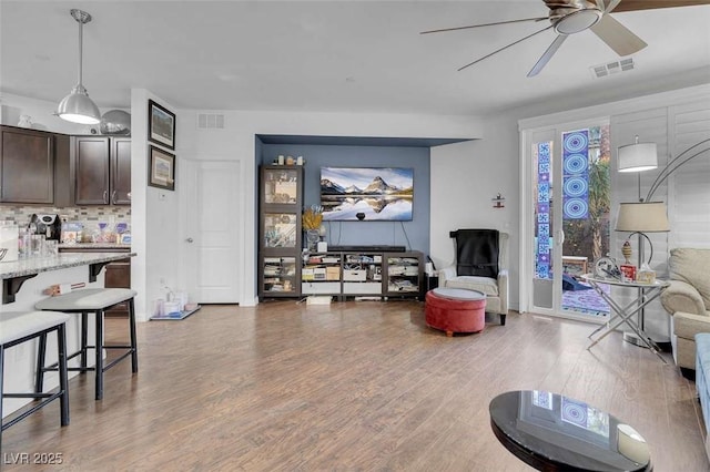 living room with ceiling fan and wood-type flooring