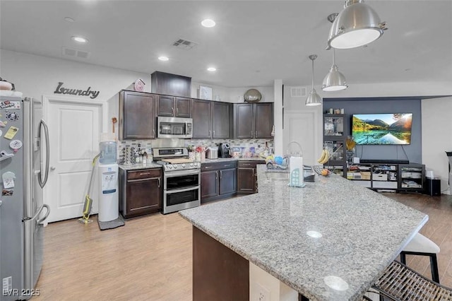 kitchen featuring appliances with stainless steel finishes, decorative light fixtures, sink, and dark brown cabinets