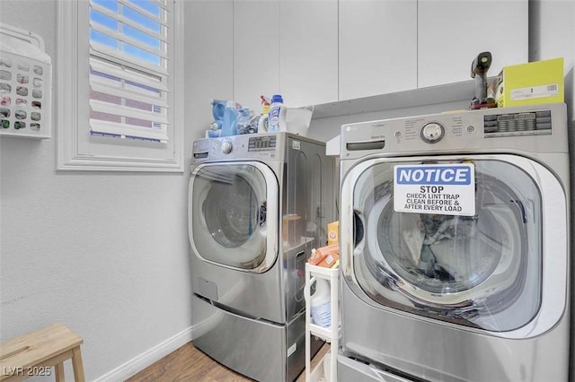 washroom with washing machine and dryer and hardwood / wood-style floors