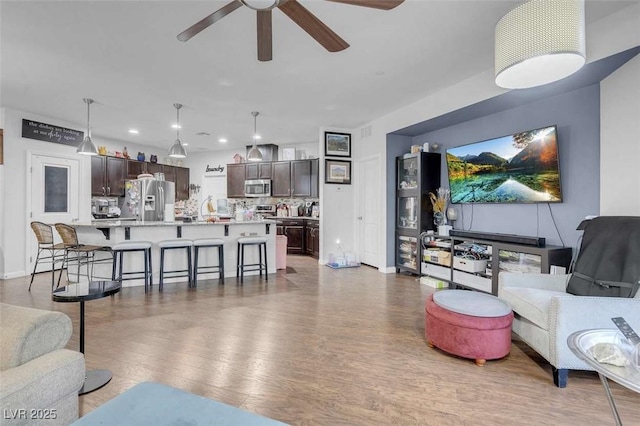 living room with ceiling fan and dark hardwood / wood-style flooring