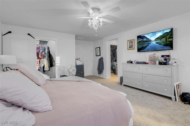 carpeted bedroom featuring ceiling fan, a spacious closet, and a closet