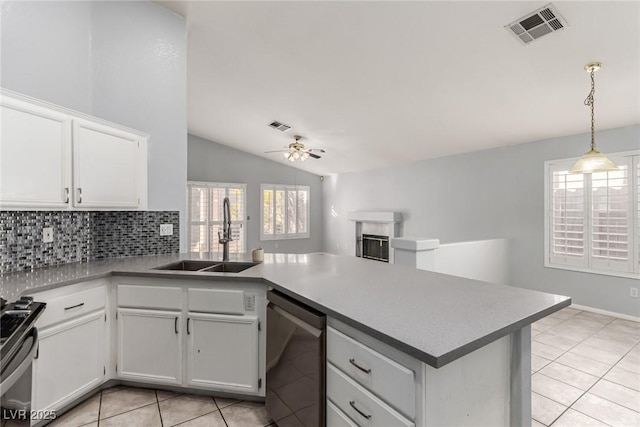 kitchen with appliances with stainless steel finishes, decorative light fixtures, sink, white cabinets, and kitchen peninsula