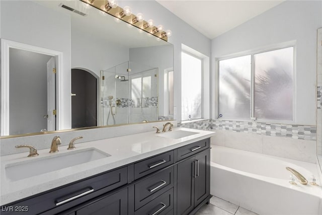 bathroom with tile patterned flooring, vanity, lofted ceiling, and independent shower and bath