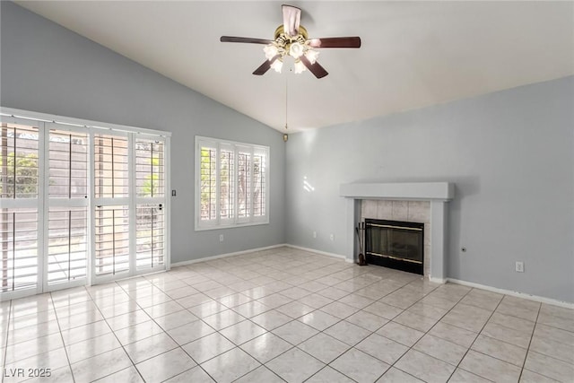 unfurnished living room featuring a tile fireplace, vaulted ceiling, light tile patterned floors, and ceiling fan