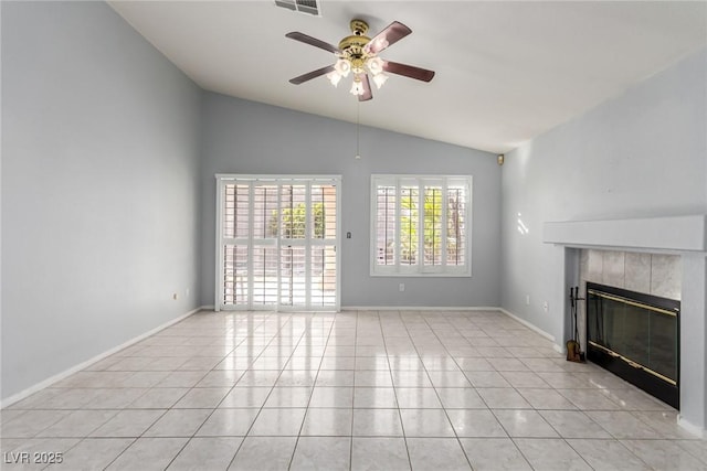 unfurnished living room with a tile fireplace, lofted ceiling, light tile patterned floors, and ceiling fan