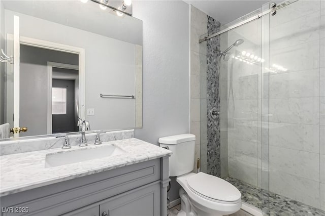 bathroom with vanity, a shower with shower door, and toilet