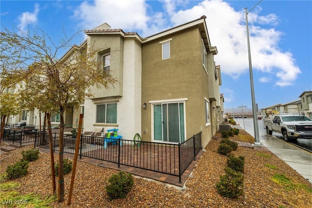 view of property exterior featuring stucco siding, a tile roof, and a patio