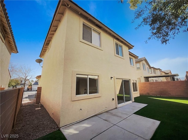 rear view of property featuring a patio area and a lawn