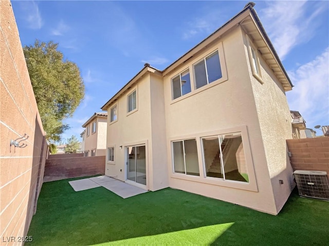 rear view of property featuring cooling unit, a lawn, and a patio area