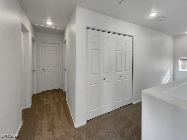 hall with dark colored carpet