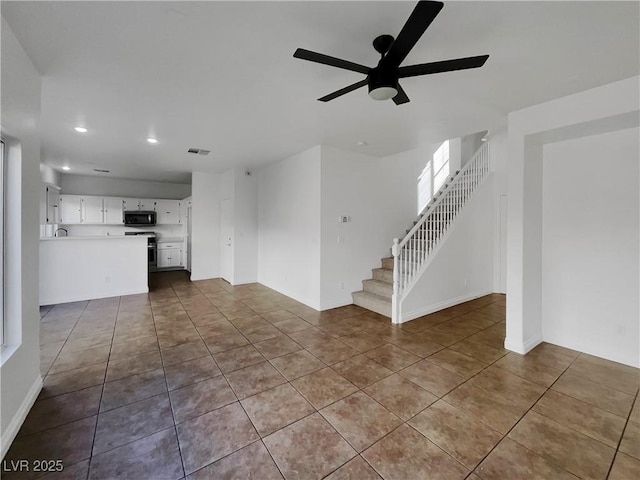 unfurnished living room featuring tile patterned flooring and ceiling fan