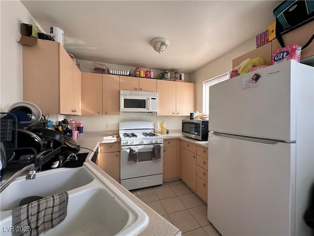 kitchen featuring sink, light brown cabinets, white appliances, and light tile patterned floors