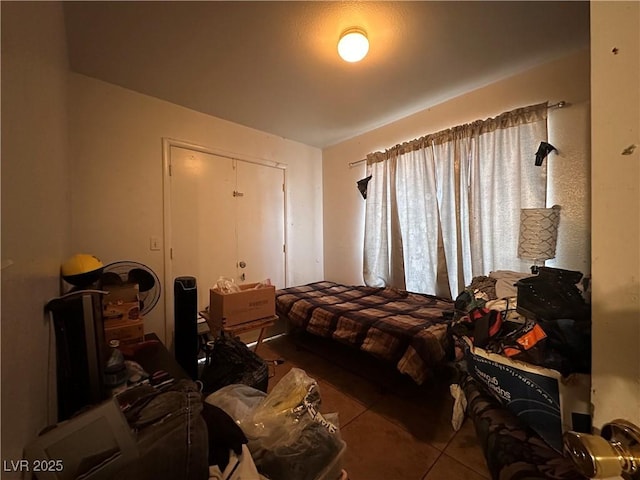 bedroom with tile patterned flooring and a closet