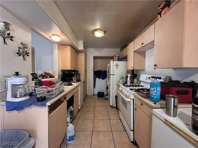 kitchen featuring light tile patterned floors and white appliances