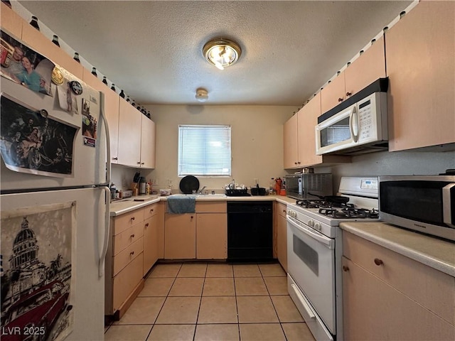 kitchen featuring light tile patterned floors, white appliances, and a textured ceiling