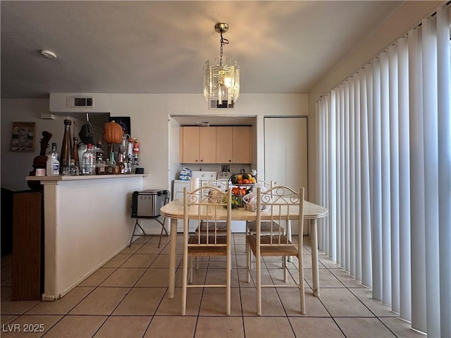 tiled dining area with an inviting chandelier