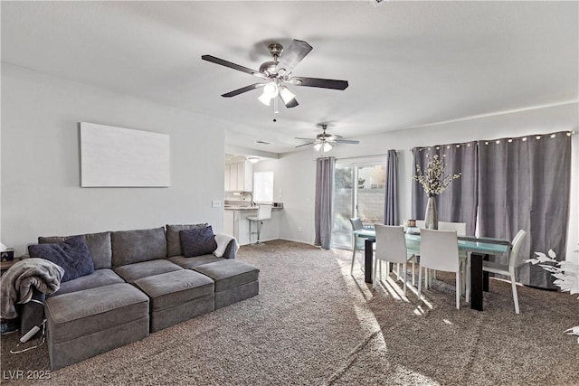 living room with sink, dark carpet, and ceiling fan