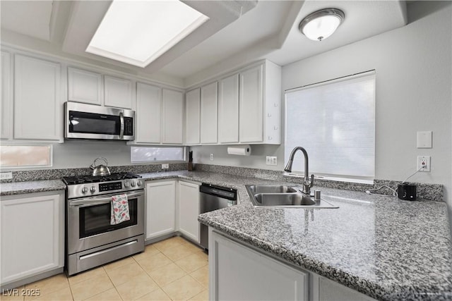 kitchen featuring white cabinetry, sink, light tile patterned floors, kitchen peninsula, and stainless steel appliances