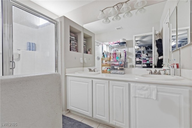 bathroom with walk in shower, tile patterned floors, and vanity