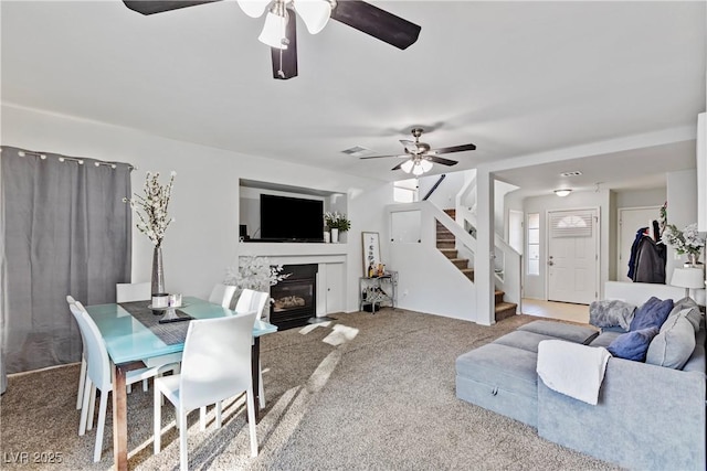 carpeted living room with ceiling fan