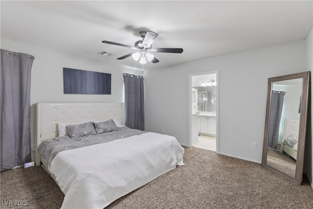 bedroom featuring light carpet, ensuite bath, and ceiling fan