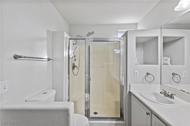 bathroom with vanity, toilet, and a shower with door