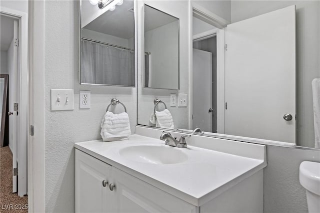 bathroom featuring vanity and toilet