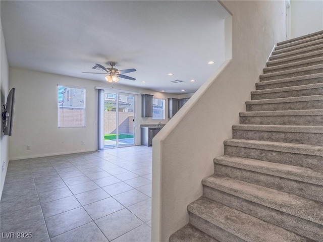 stairway with ceiling fan and tile patterned flooring