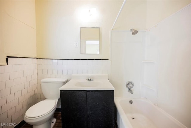 full bathroom with vanity, shower / washtub combination, tile walls, and toilet