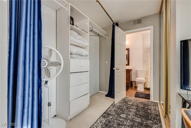 walk in closet featuring light colored carpet