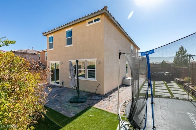 back of house with a trampoline