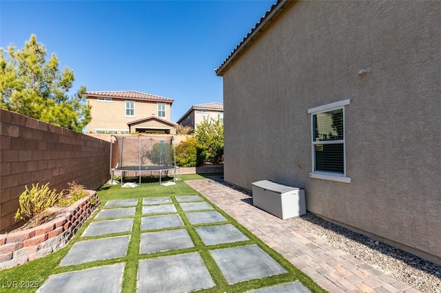 view of yard featuring a patio and a trampoline