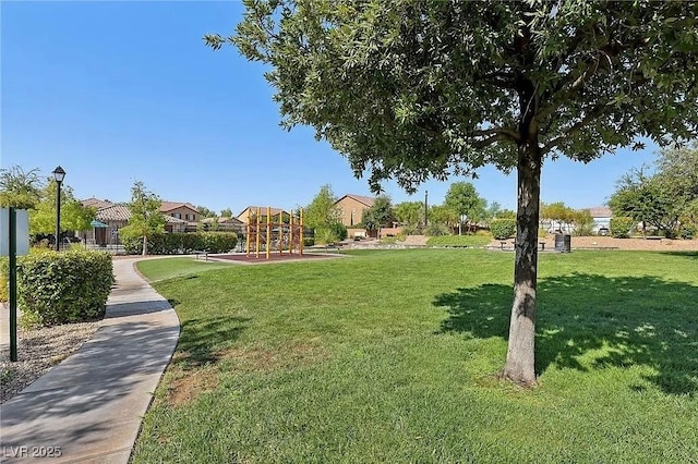 view of home's community with a playground and a yard