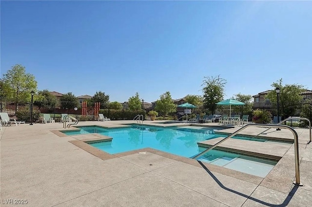 view of swimming pool with a jacuzzi and a patio area