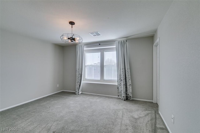 spare room featuring carpet floors and a notable chandelier