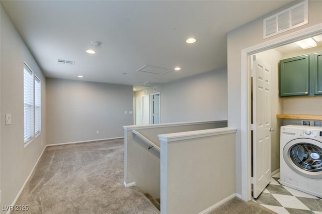 laundry room with cabinets, washer / dryer, and light colored carpet